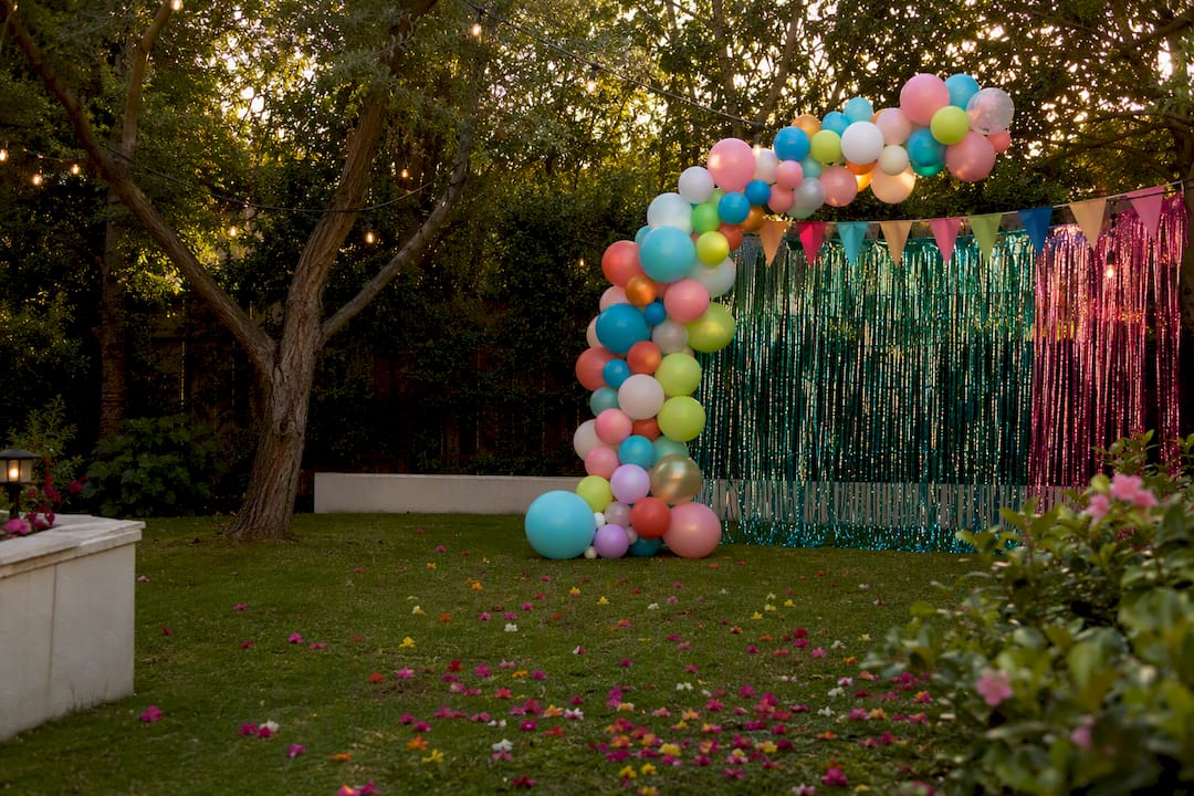 Decorated party entrance with balloon arch and backdrop