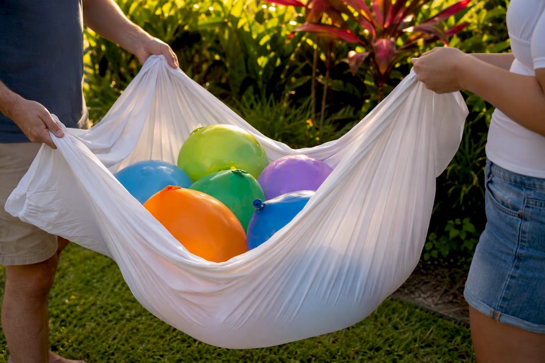 Hands carrying balloons wrapped in sheet