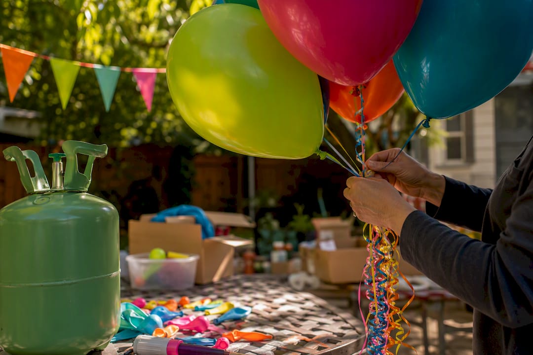 Hands filling helium latex balloons