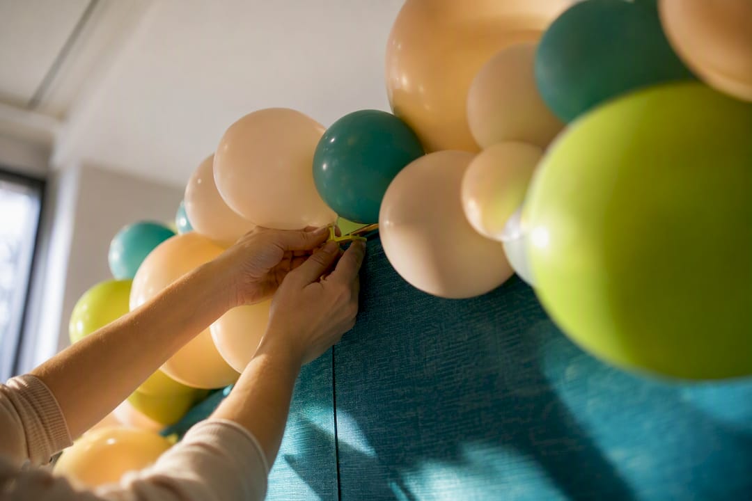 Hands securing air-filled balloon garland